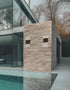 Modern building with stone facade next to a pool