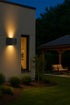 Modern house exterior with a wall light fixture and outdoor seating area at night.