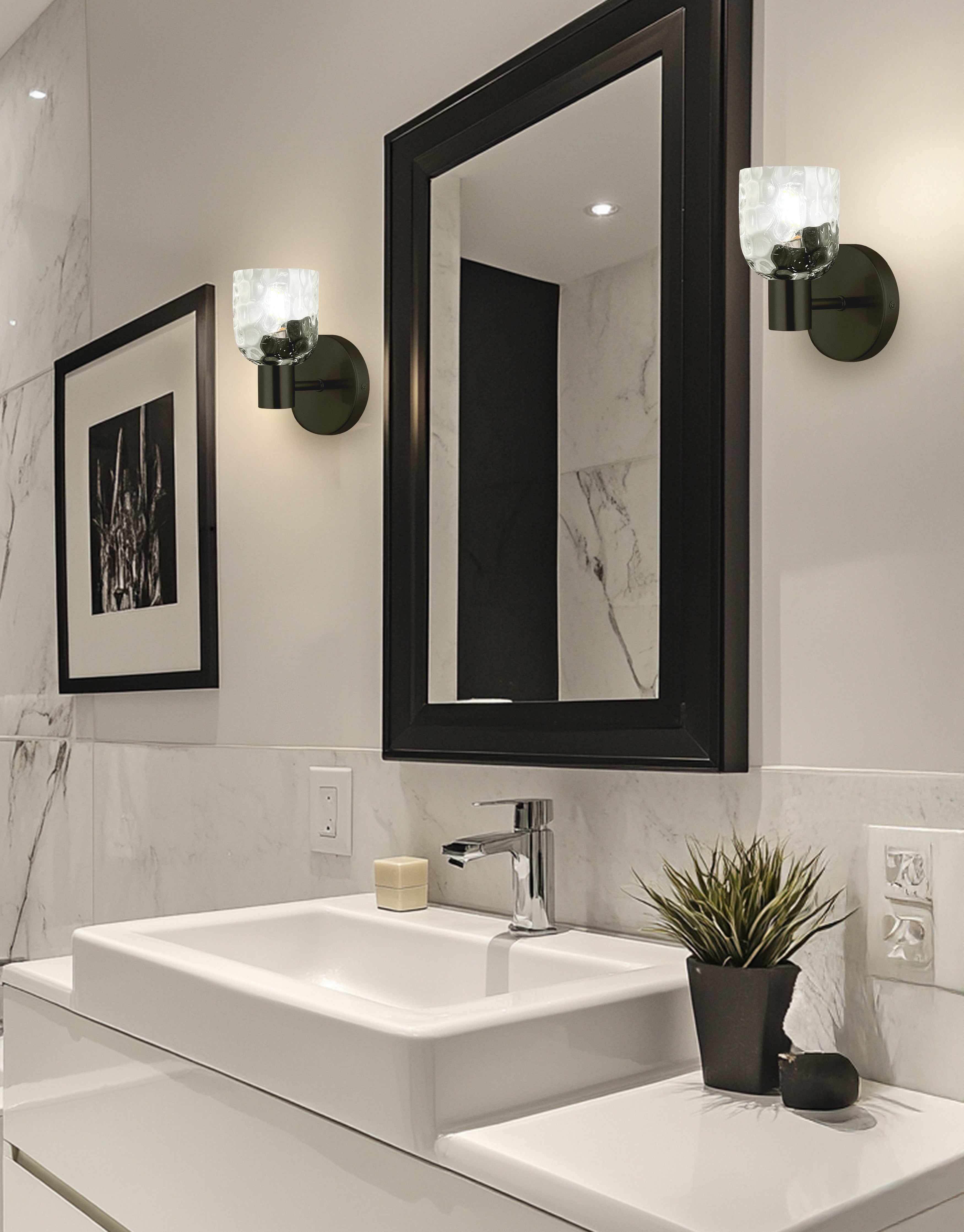 Bathroom with white sink, black-framed mirror, and decorative elements.