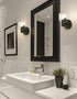 Bathroom with white sink, black-framed mirror, and decorative elements.