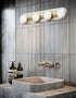 Bathroom vanity with a sink, faucet, and wall-mounted light fixture.