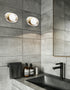Modern bathroom with gray tiles, a sink, and decorative bottles.