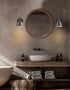 Bathroom with round mirror, wooden vanity, and decorative elements.