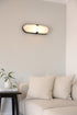 Modern wall light fixture above a beige sofa in a living room.