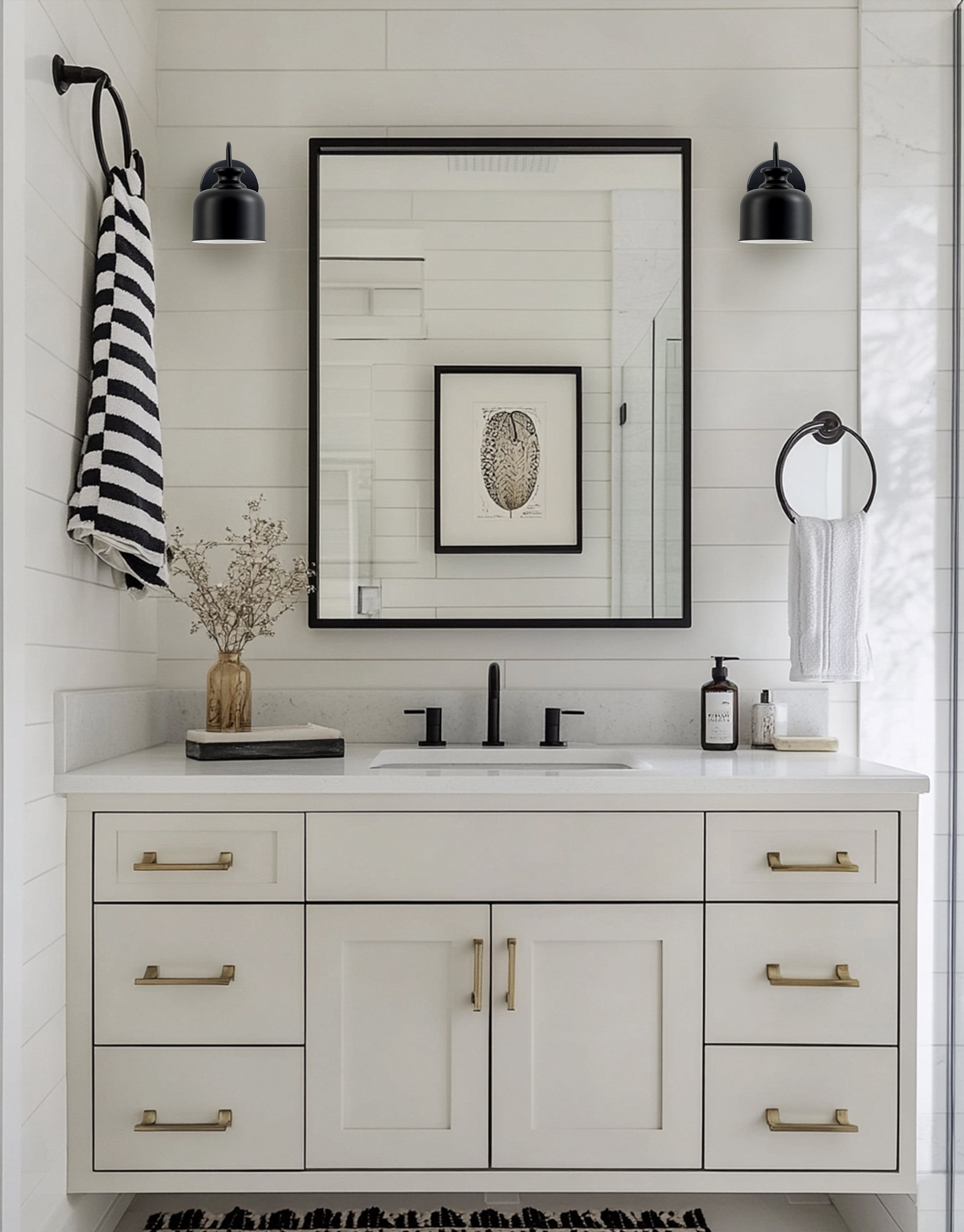 Bathroom vanity with mirror, sink, and decorative items against a white tiled wall.